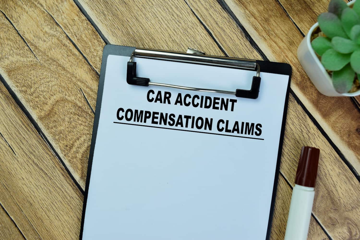 Car accident compensation claims document on clipboard representing insurance benefits and financial recovery after a New York car crash.